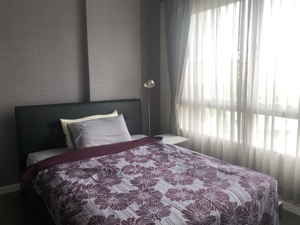 For sale: D Condo Campus Rangsit Phase 1. Bedroom has double-layered curtains that can be pulled closed to block UV light. Wallpaper on the walls. A h