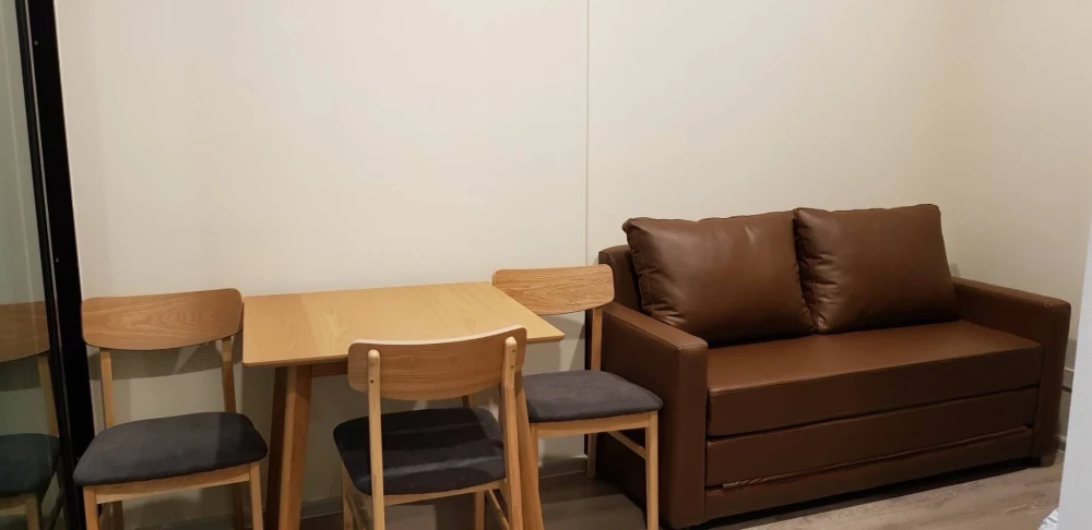 Knightsbridge Collage Ramkhamhaeng for rent, a cozy room with complete electrical appliances and a comfortable brown sofa. Don't miss it!