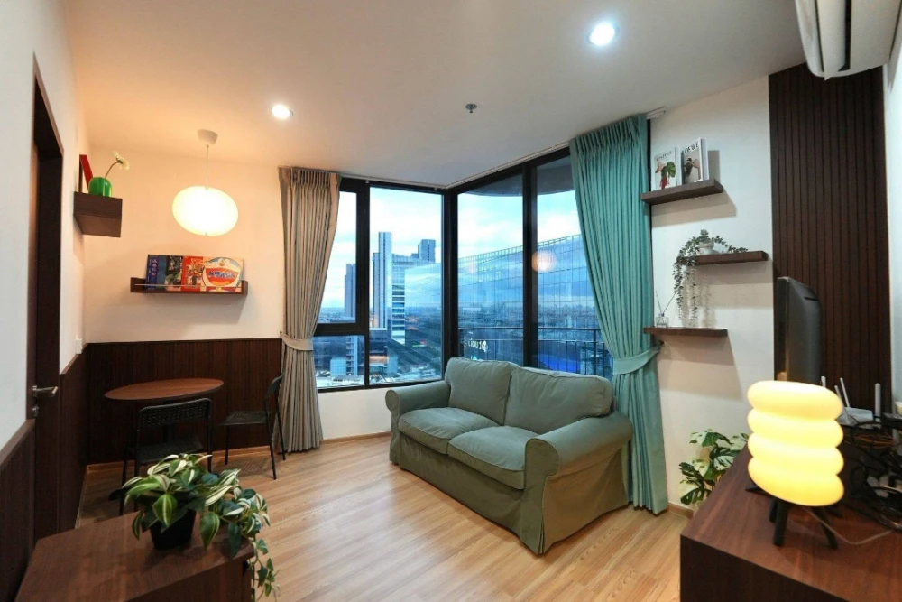 For rent: Skyrise Avenue Sukhumvit 64. The unit features a "Warm Living Suite" style, combining dark wood accents with light wood flooring, warm light