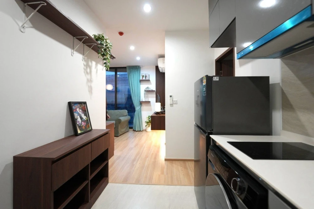For rent: Skyrise Avenue Sukhumvit 64. The unit features a "Warm Living Suite" style, combining dark wood accents with light wood flooring, warm light