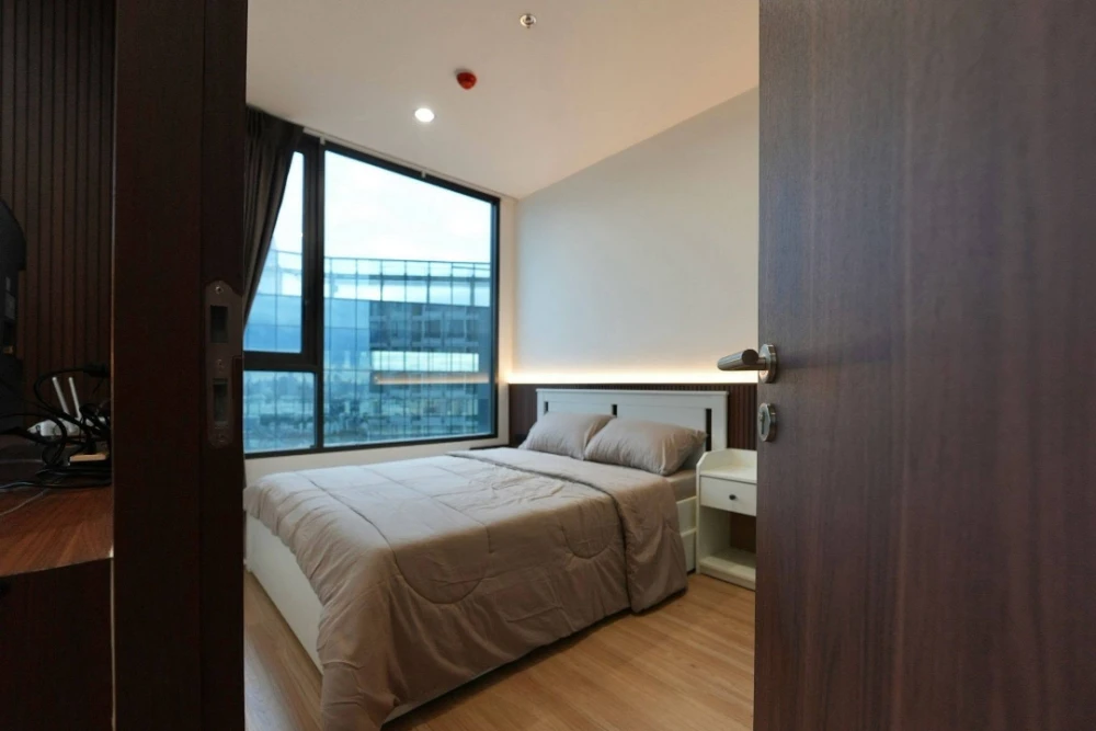 For rent: Skyrise Avenue Sukhumvit 64. The unit features a "Warm Living Suite" style, combining dark wood accents with light wood flooring, warm light