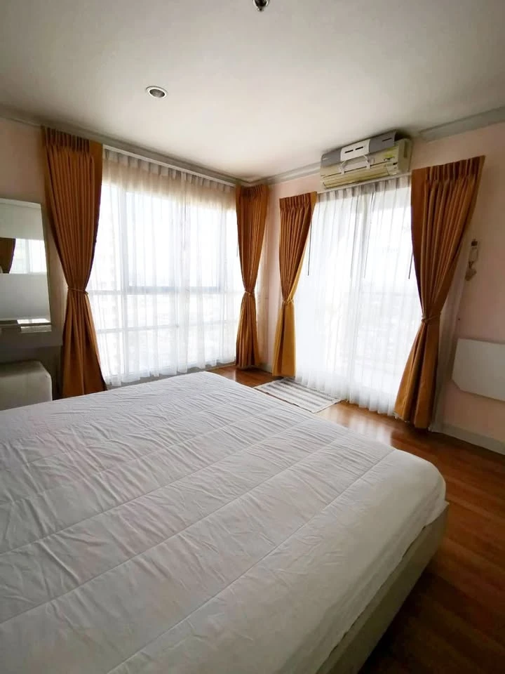 For rent: Lumpini Place Rama 9-Ratchada, 25th floor, very high, view of a large, shady garden and lake. The room is at the corner of the building.