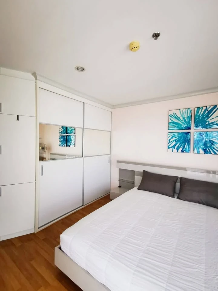 For rent: Lumpini Place Rama 9-Ratchada, 25th floor, very high, view of a large, shady garden and lake. The room is at the corner of the building.